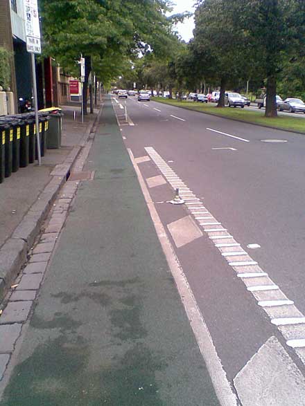 A stretch of the eastbound bike lane on Albert St, East Melbourne, showing a broken pole mounting.